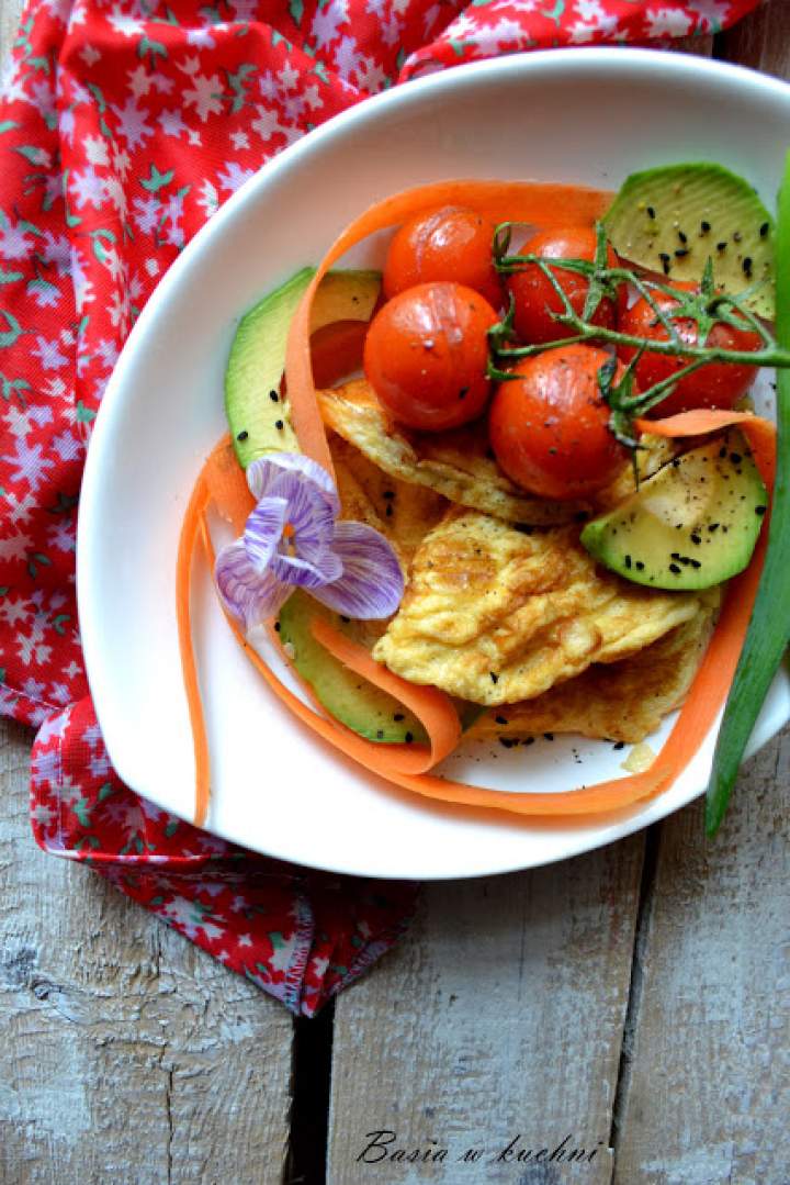 Omlet z pomidorkami, marchwią, awokado oraz czarnuszką.