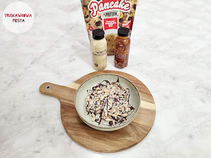 Proteinowe naleśniki owsiane z białkiem, toppingiem o smaku czekolady mlecznej, orzechów laskowych i białej czekolady, orzeszkami ziemnymi i nasionami słonecznika